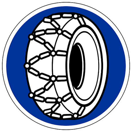 Montierte Schneeketten auf einem Autoreifen im Schnee